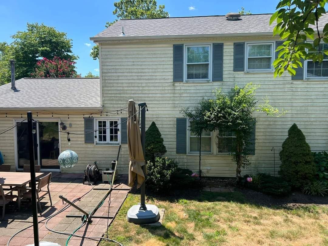 the backyard of a house with a patio and umbrella