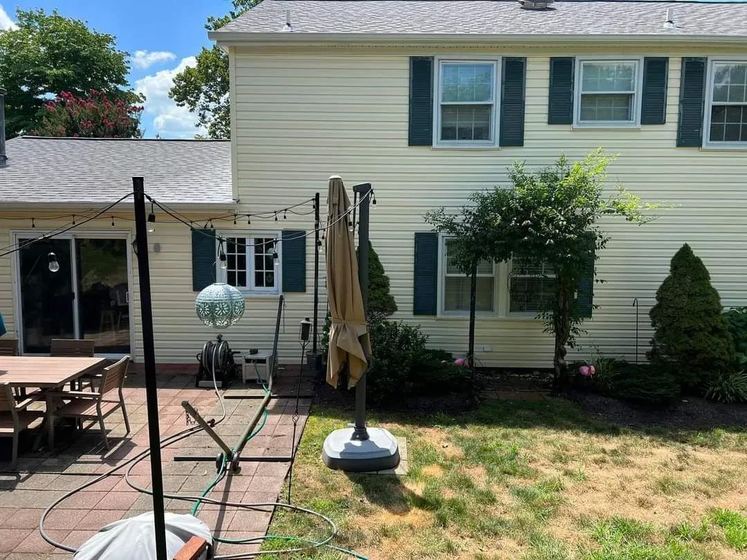 the backyard of a house with a patio and umbrella