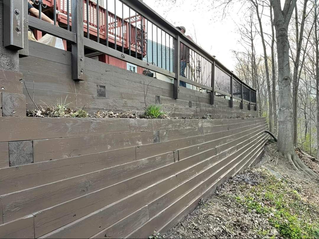 a wooden fence with a railing in the woods