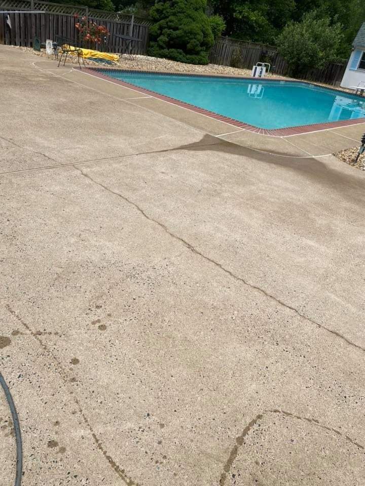 a large swimming pool is surrounded by a concrete patio