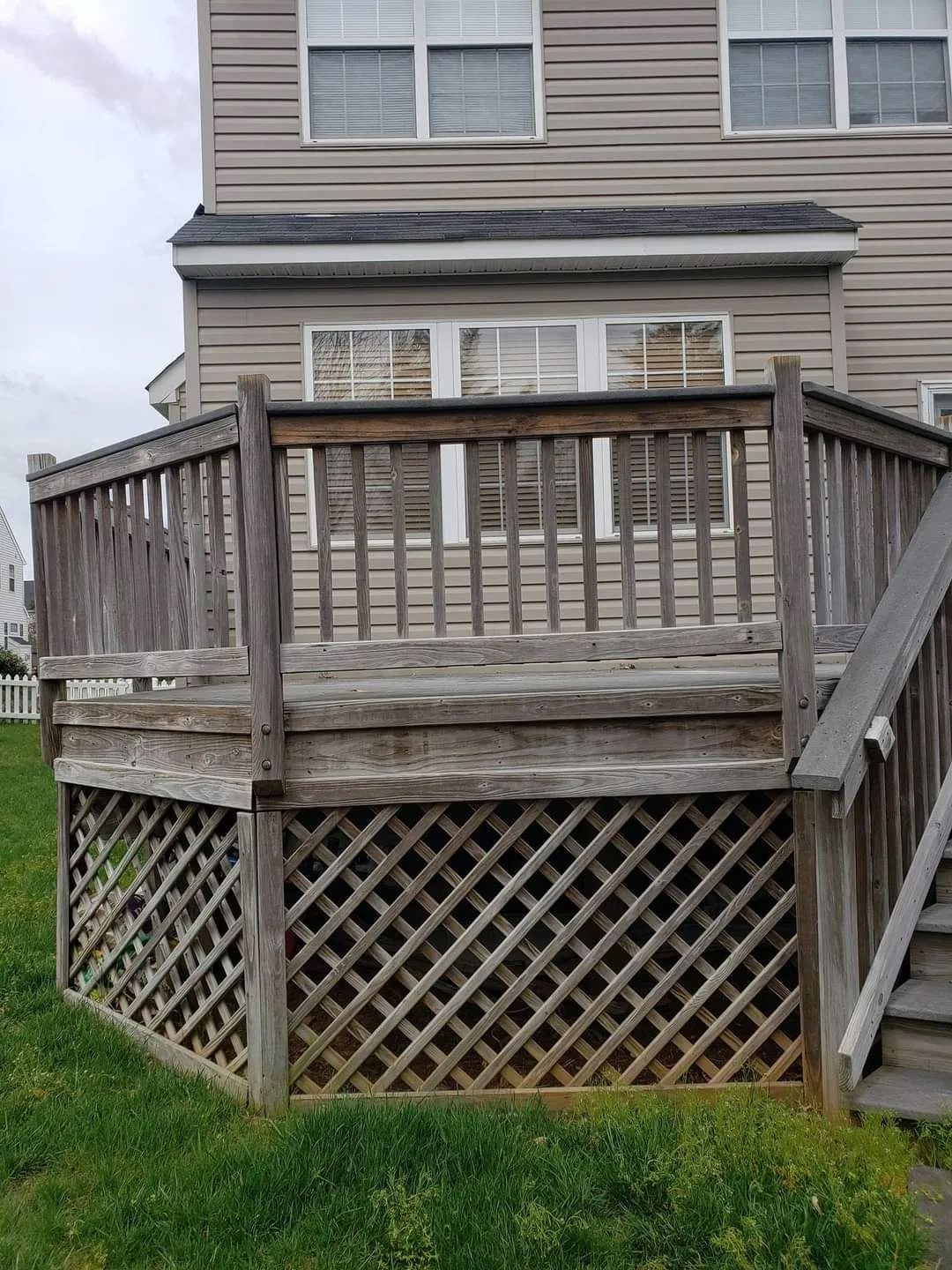 a wooden deck with stairs in front of a house