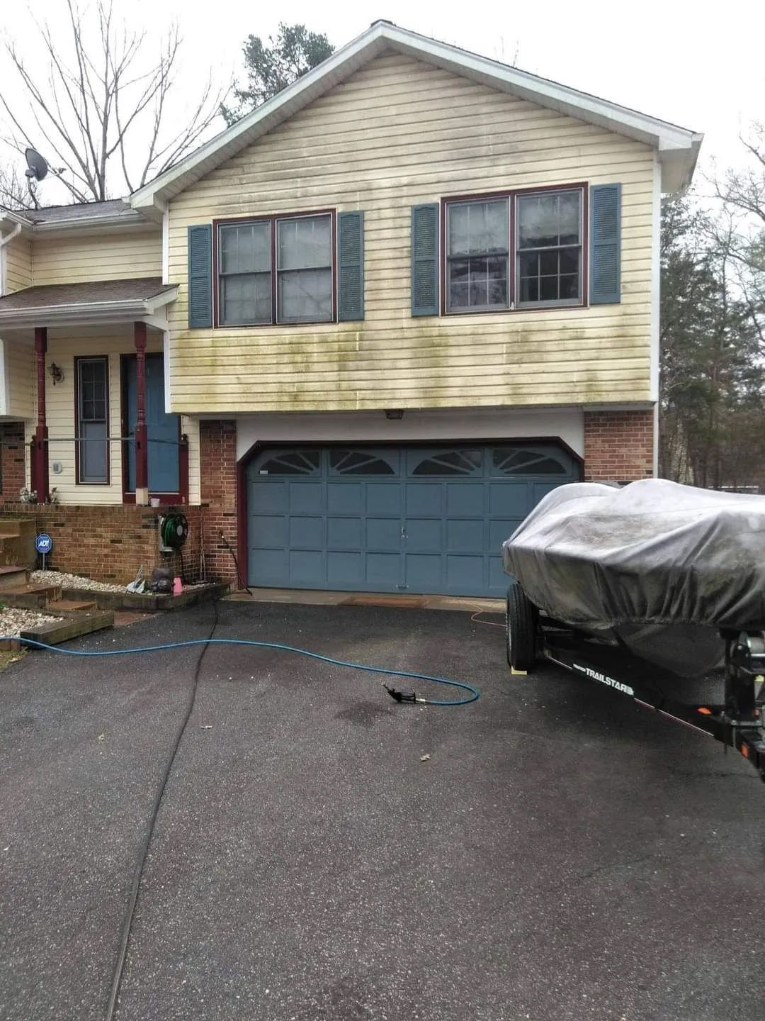 a boat is parked in front of a house with a blue garage door