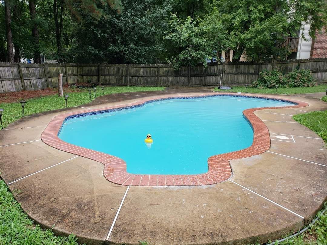 a large swimming pool in a backyard with a yellow ball in it