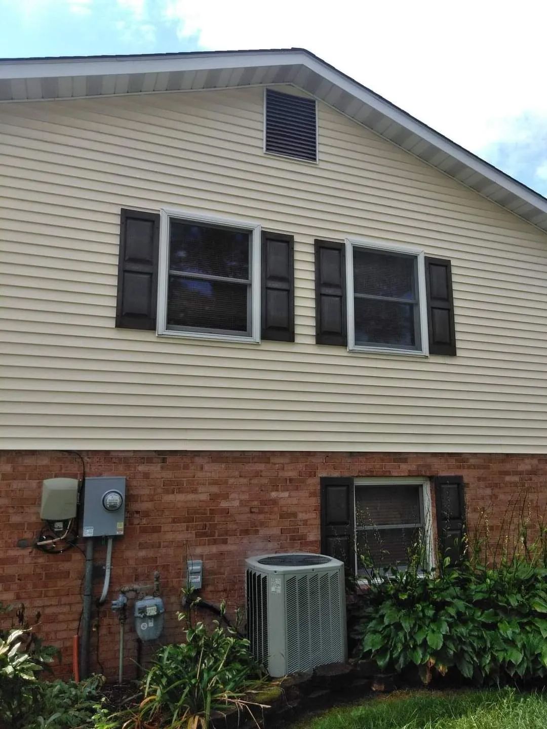 a house with a lot of windows and an air conditioner on the side of it