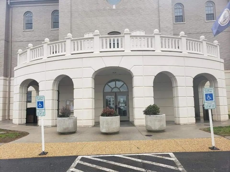 a large white building with a handicapped parking spot in front of it