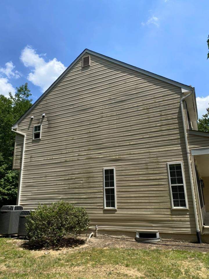 the back of a house with a lot of windows and a blue sky in the background