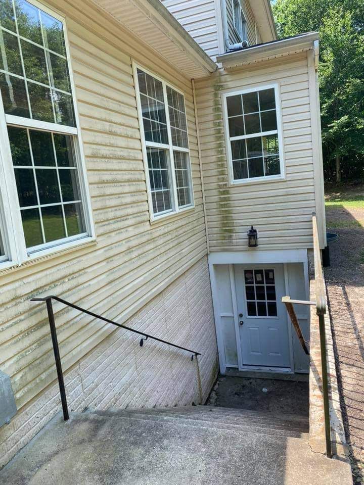 a house with stairs leading up to the basement and a white door