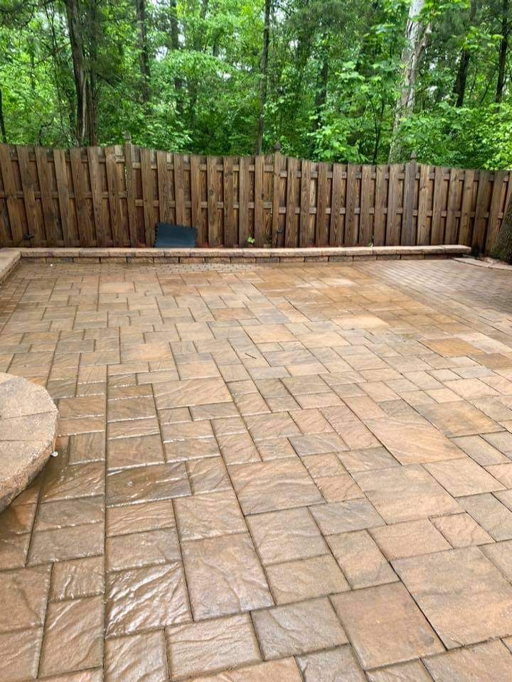 a brick patio with a wooden fence in the background