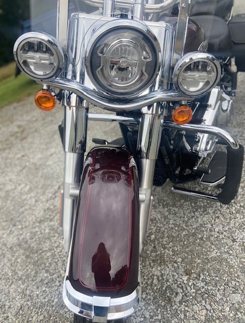 A harley davidson motorcycle is parked on a gravel road.