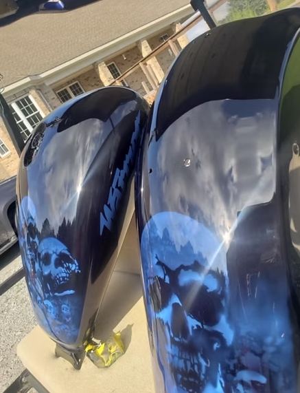 A pair of motorcycle tanks with skulls painted on them