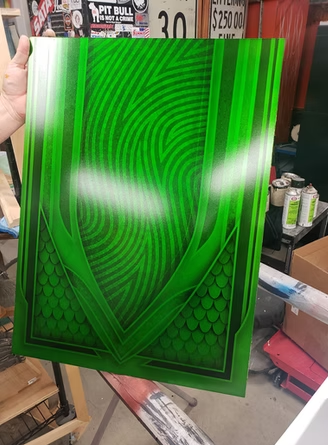 A person is holding a green painting in their hand.