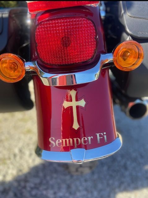A red motorcycle with semper fi written on the back