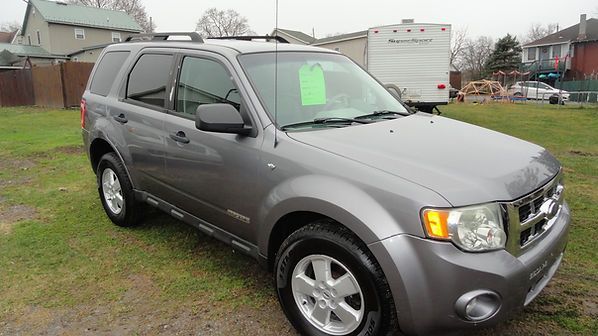 Gray SUV parked on grass beside houses, with a bright green sign in the windshield.