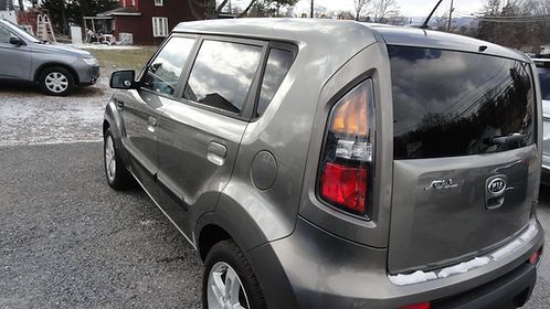 Gray Kia Soul parked in a lot, rear three-quarter view on a snowy day
