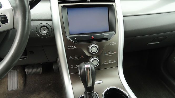 Car dashboard with center console, touchscreen display, climate controls, and gear shift.