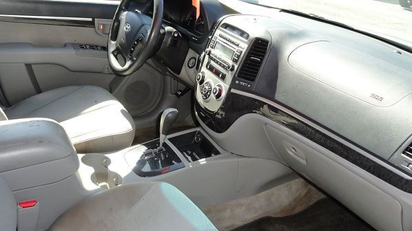 Car interior with light leather seats, dashboard, steering wheel, and center console in sunlight