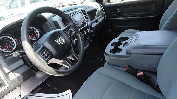 Truck cab interior with black dashboard, gray seats, and center console cup holders