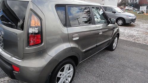Gray compact SUV parked in a lot, side view with a red taillight visible.