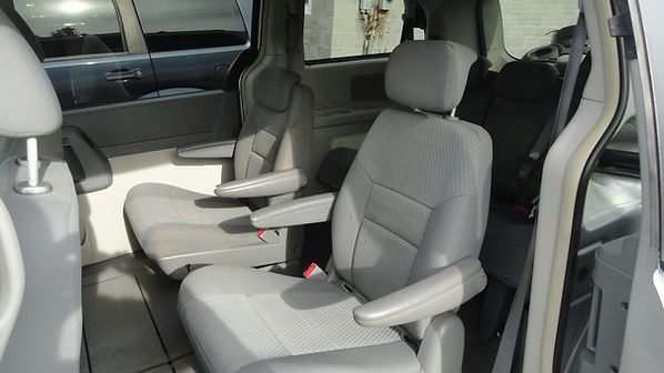 Gray car interior with two beige captain’s chairs and center armrests