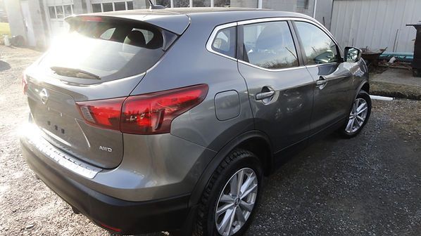 Gray SUV parked outdoors in a lot, rear three-quarter view.