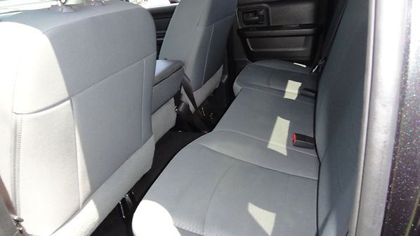 Back seat of a car with gray upholstery and tan tape strips on the seat cushions