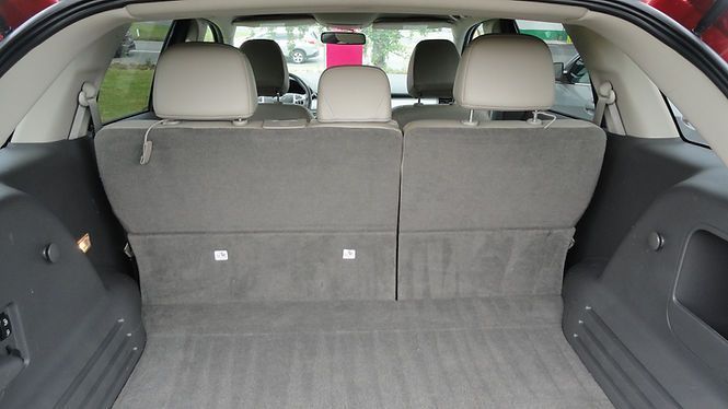 Open car trunk with folded rear seats and gray cargo area upholstery