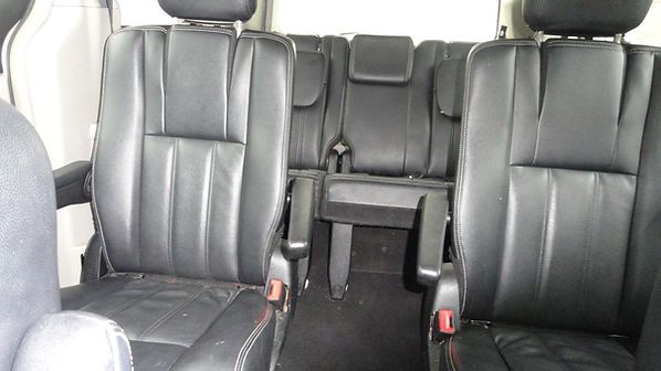 Black leather car interior with two rear captain seats and a center aisle