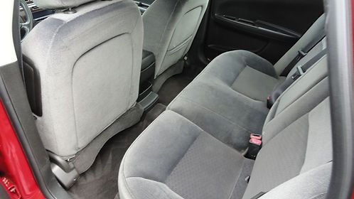 Car interior with gray fabric rear seats and the back of the front passenger seat visible.
