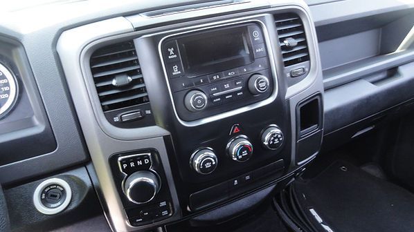 Car dashboard center console with radio, climate controls, and gear selector in gray interior