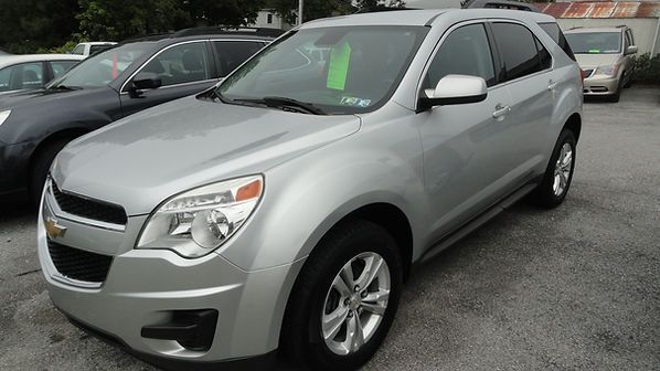 Silver SUV parked in a car lot on a wet day, front-left view