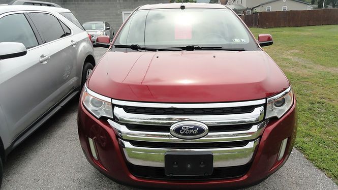 Red Ford SUV parked beside a silver car on a driveway, front view.