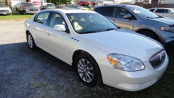 Silver sedan parked in a dealership lot on a sunny day