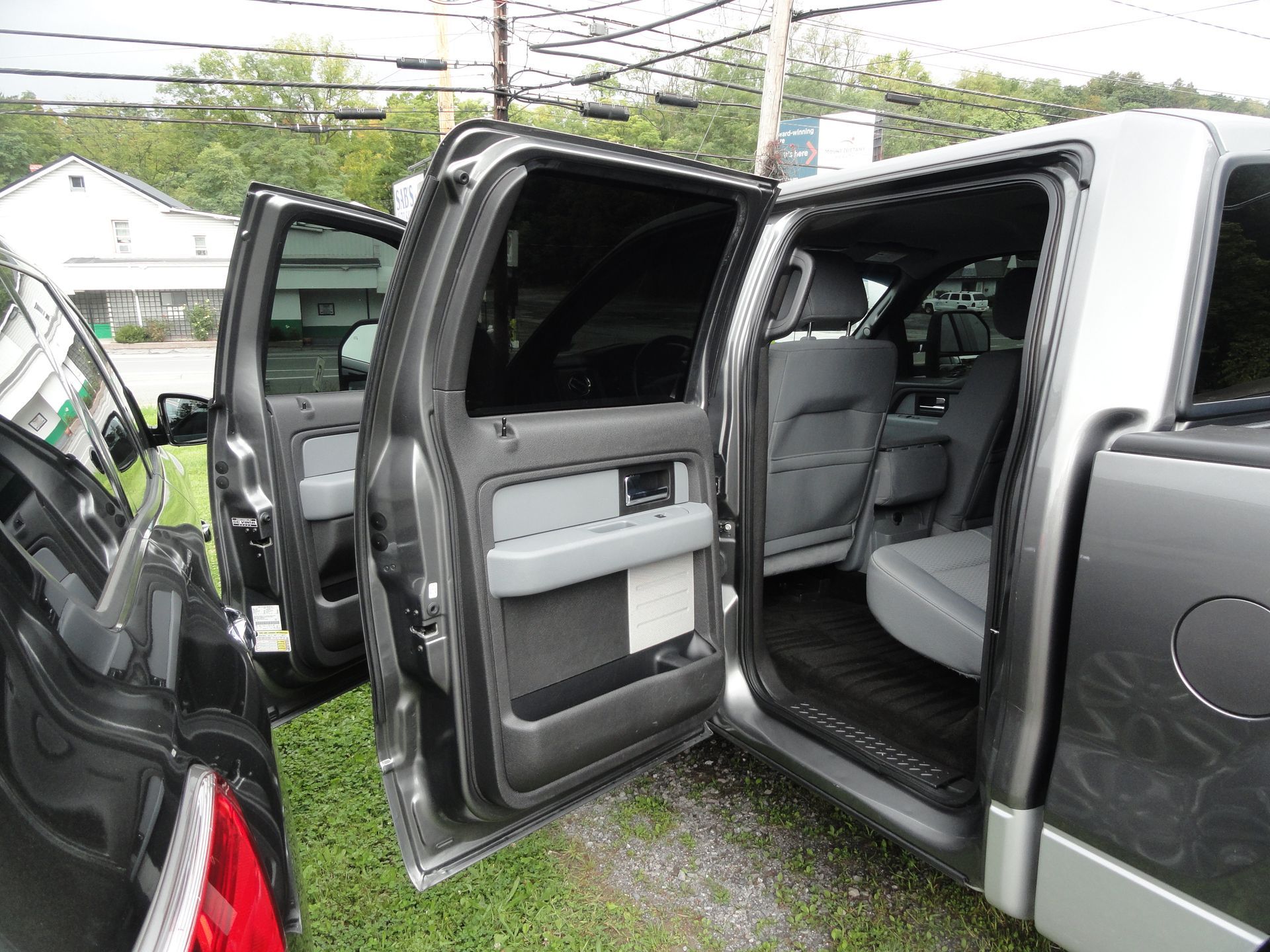 Open SUV with rear and front passenger doors wide open, showing gray interior seats.