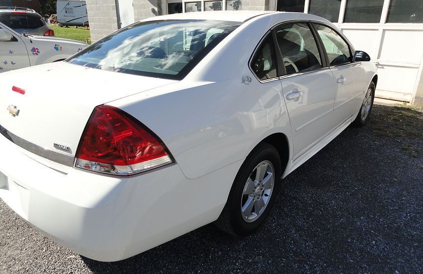 White sedan parked outside a building in daylight