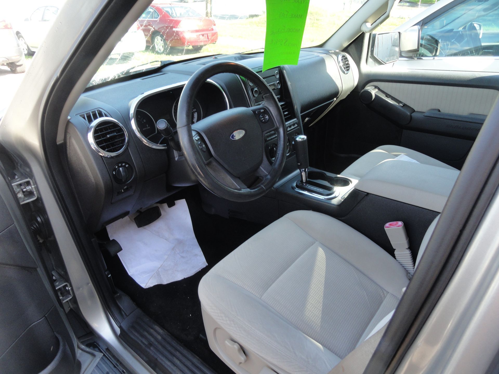 SUV interior with black dashboard, gray seats, steering wheel, and center console visible from the open door