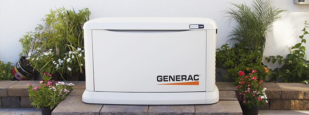 A white Generac generator installed outdoors, surrounded by plants and flowers in a residential setting.