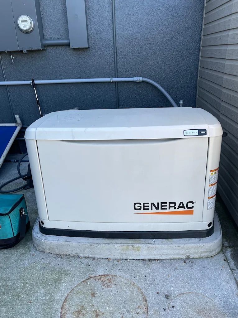 White Generac generator on concrete base, outside a building.