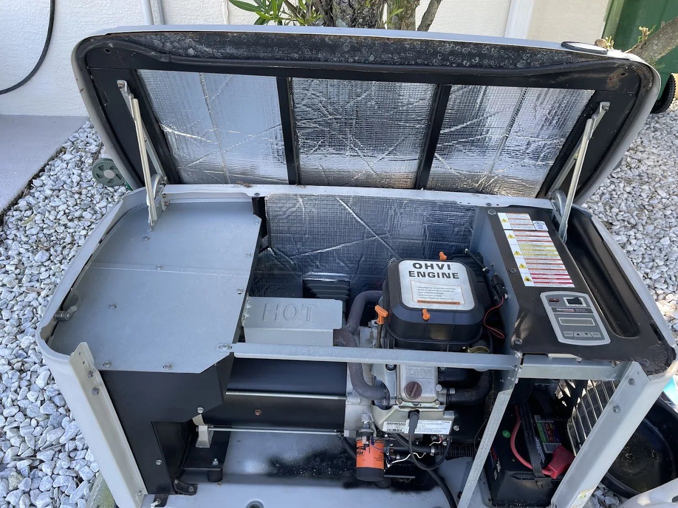 Generator with open top, silver and black, inside showing engine components.