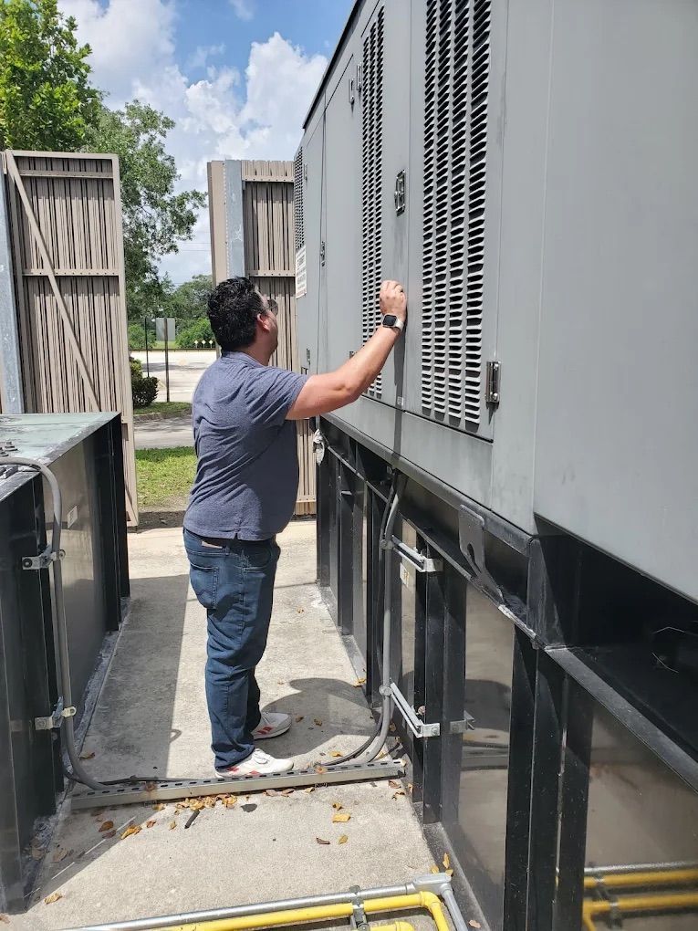 Person in blue shirt examining a large metal unit outside.