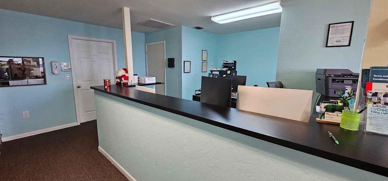 Reception area with a black counter, light blue walls, and a door.