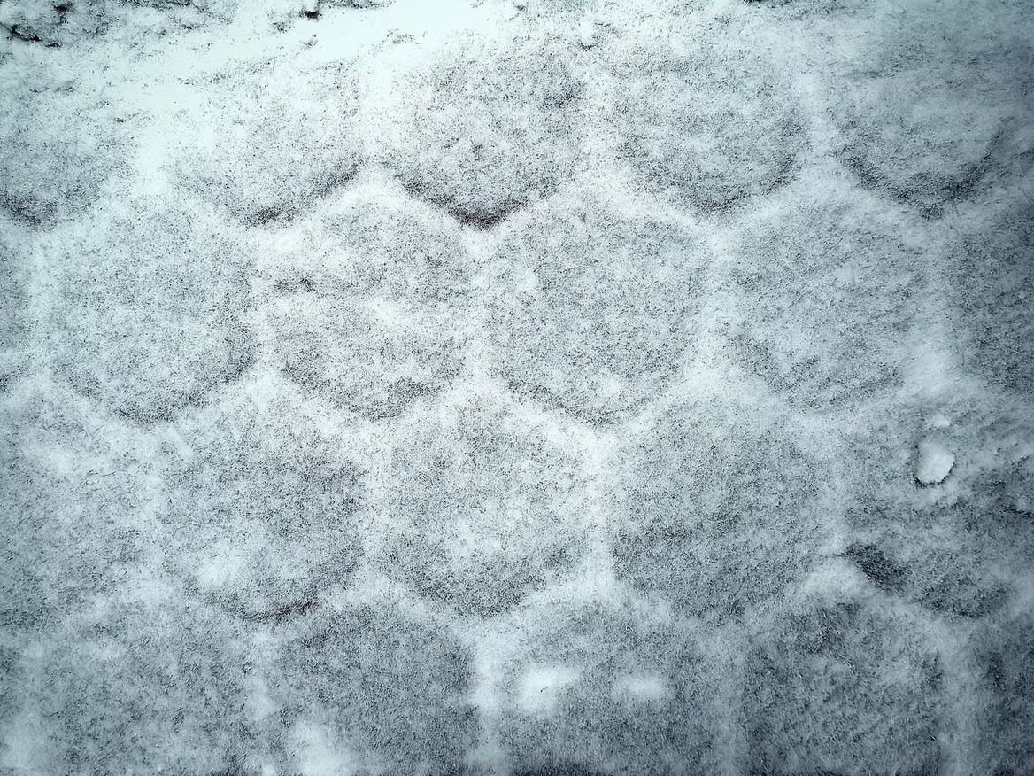 Snow-covered surface with a hexagonal pattern pressed into it.
