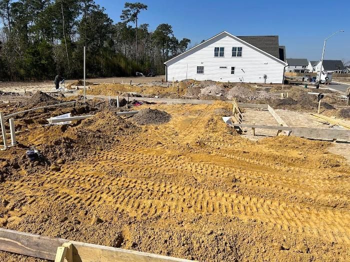 A construction site with a house in the background