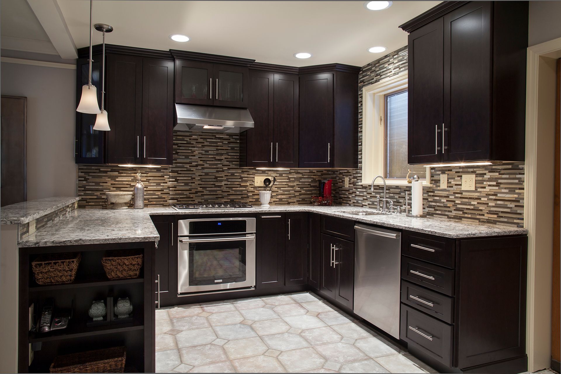 A kitchen with dark cabinets and stainless steel appliances