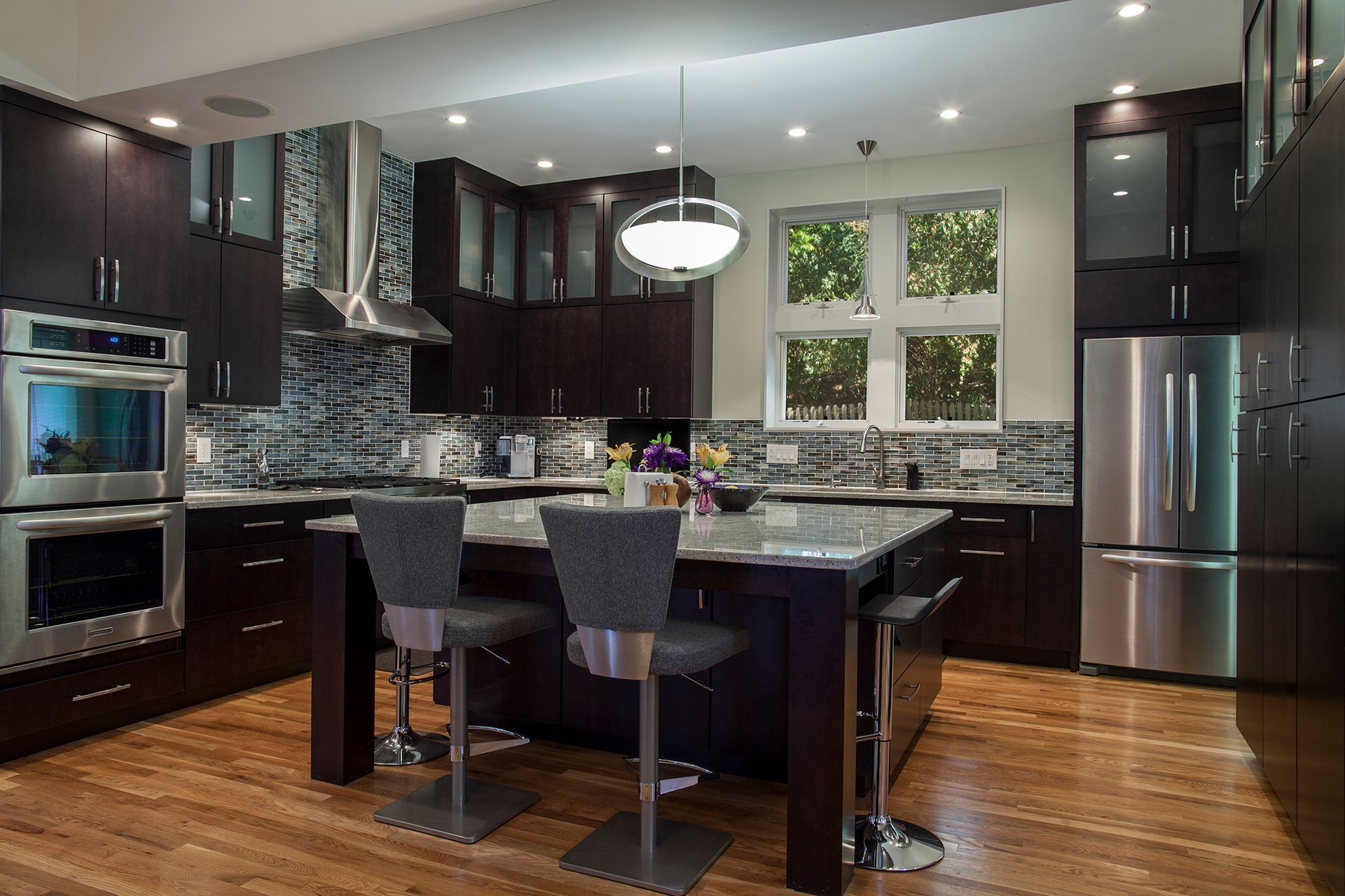A kitchen with stainless steel appliances and wooden floors