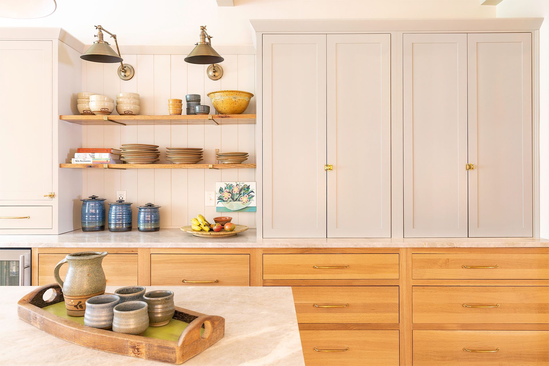 A kitchen with wooden cabinets and a wooden tray on the counter.