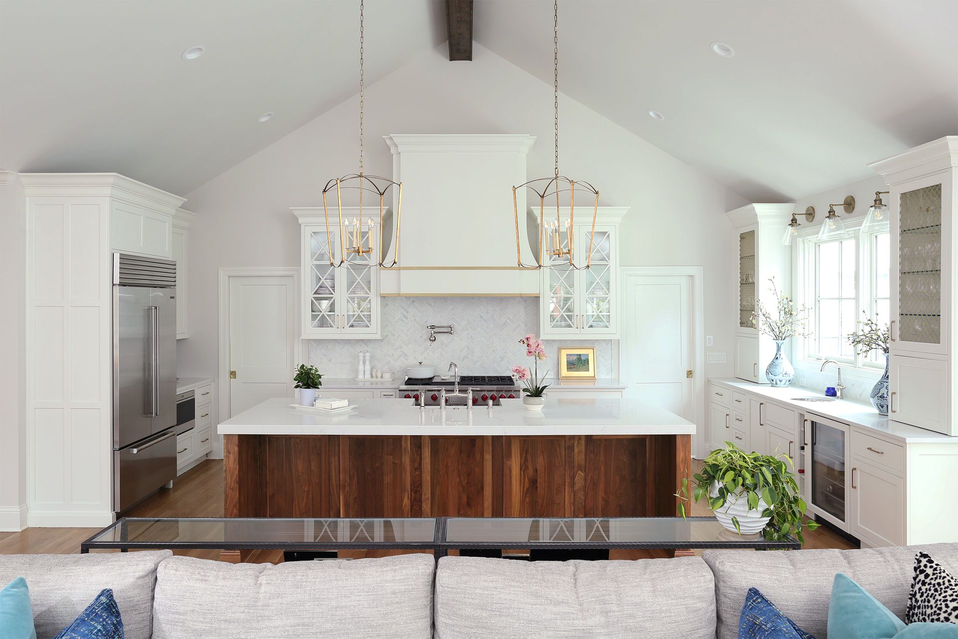 A living room with a couch and a kitchen in the background.