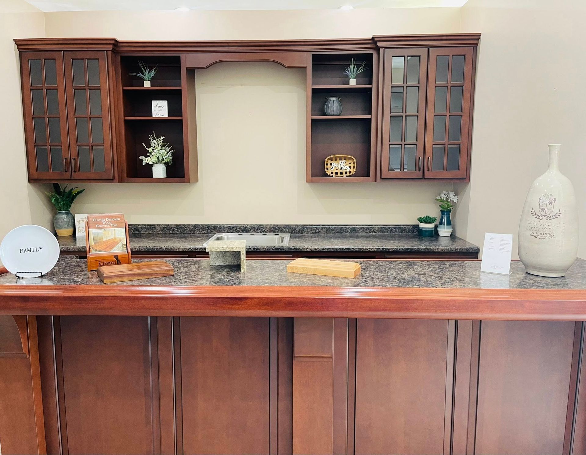 A kitchen counter with wooden cabinets and a granite counter top.