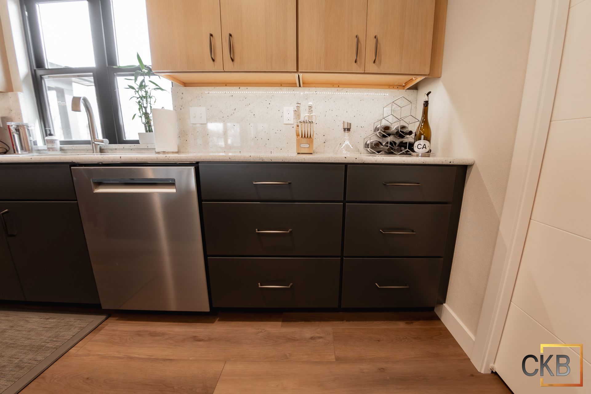 A kitchen with black cabinets, stainless steel appliances, a sink, and a dishwasher.