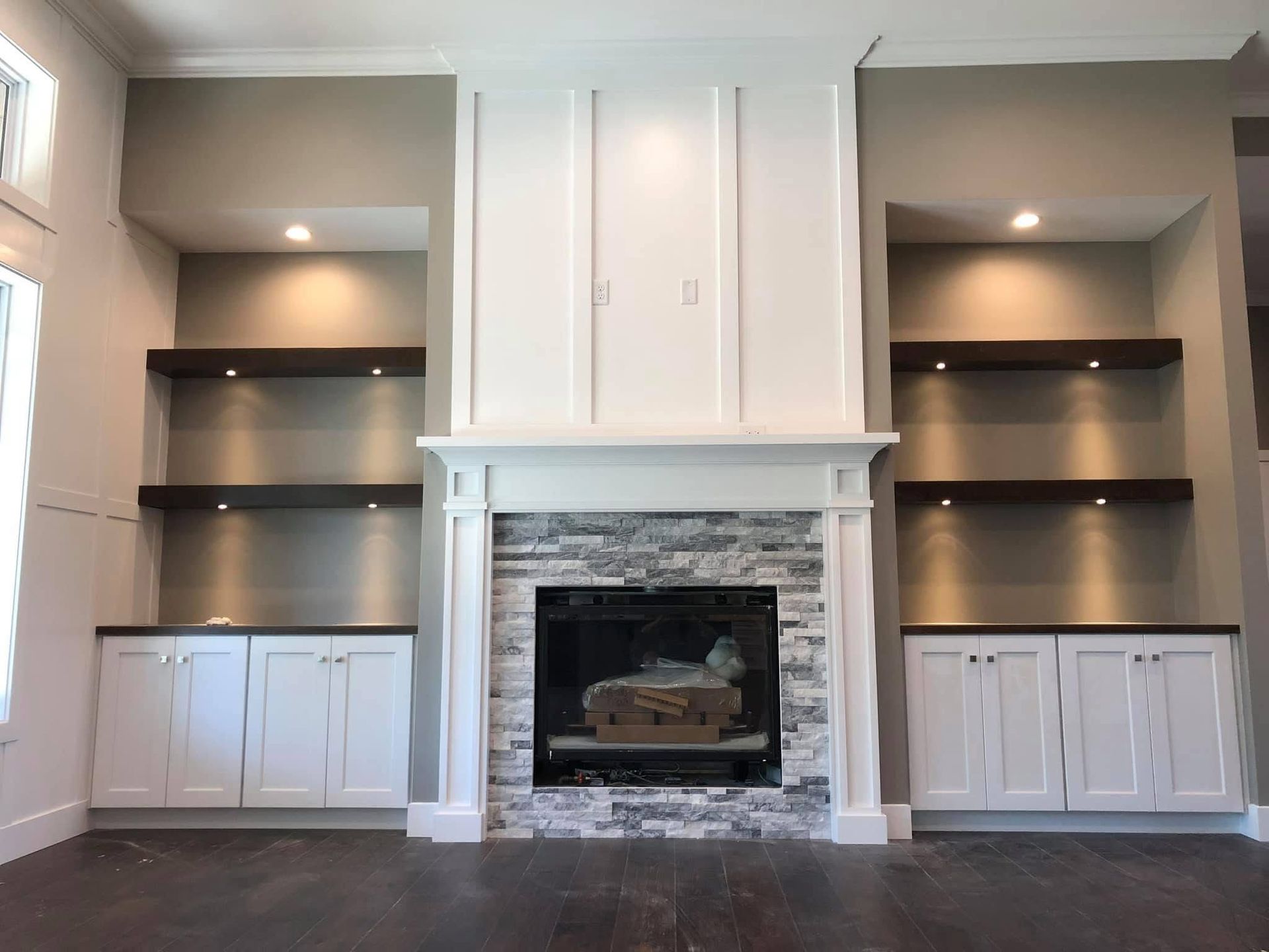 A living room with a fireplace and built in shelves