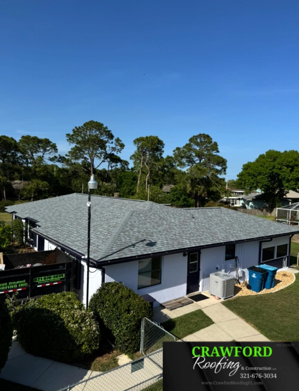 An aerial view of a house with a crawford roofing sign in the foreground